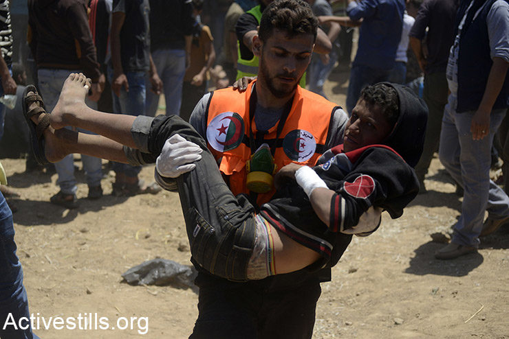 A medic carries a Palestinian child during a protest in the Gaza Strip