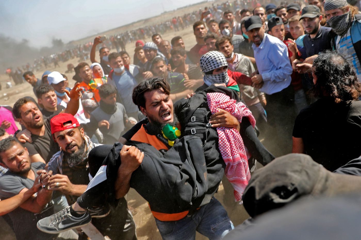 Click to enlarge Palestinians carry a demonstrator