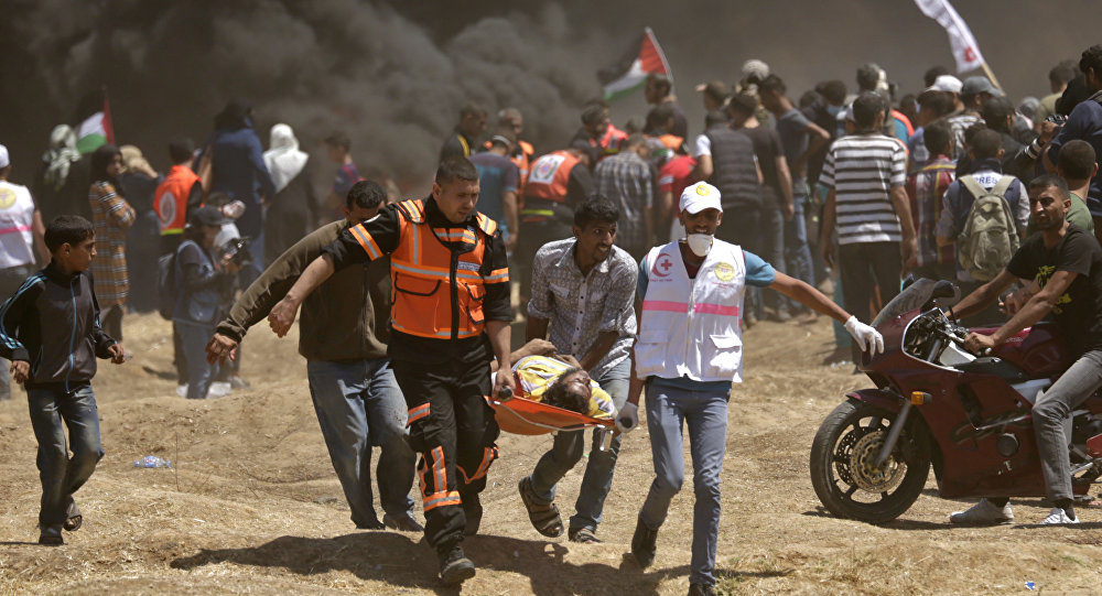 Palestinians carry a demonstrator injured during clashes with Israeli forces