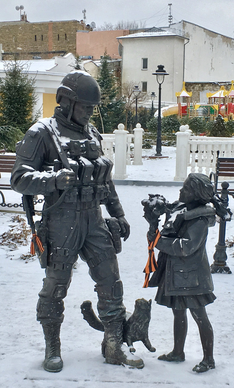 Click to enlarge Locals hang orange and black “Victory” ribbons around statues symbolising peace, in Simferopol