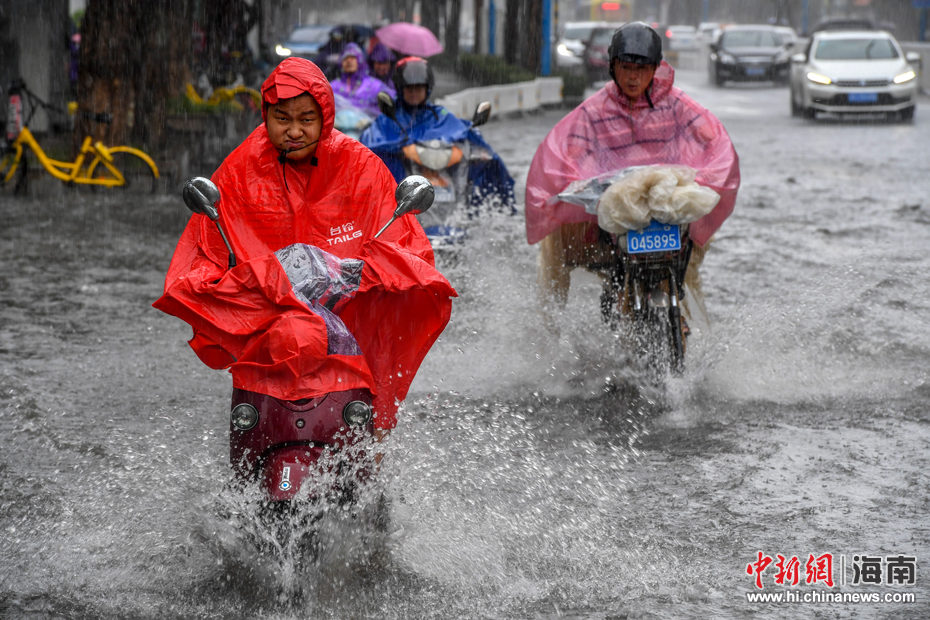 Click to enlarge locals ride motorbikes on flooded street in heavy rain caused by typhoon Ewiniar, in Haikou, South China's Hainan province, June 6, 2018.