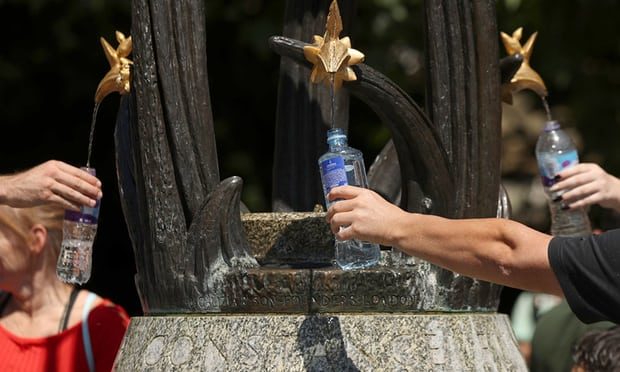 People fill their bottles from a water fountain