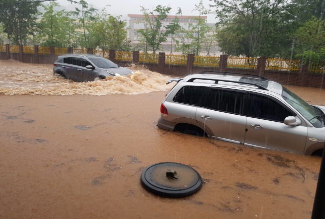 Cars are submerged in a street in Boseong-gun, South Jeolla Province on Sunday morning.