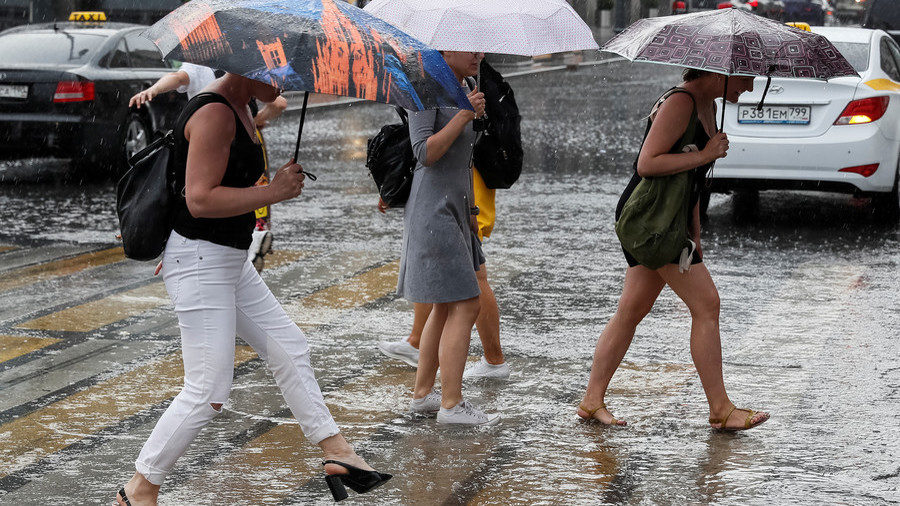 Click to enlarge People cross a street during heavy rain in central Moscow, Russia on June 30, 2018