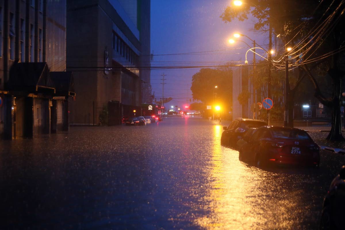 UNDER WATER: The glow of streetlights reflect on flood waters at Independence Square, Port of Spain.