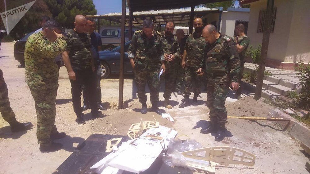 Syrian servicemen are seen near a downed drone