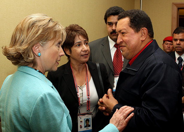 Venezuelan President Hugo Chavez listens to US Secretary of State Hilary Clinton