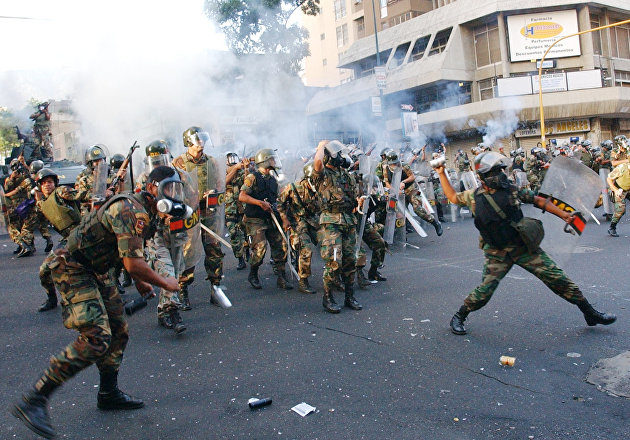 Click to enlarge National Guards throw tear gas at President Hugo Chavez supporters