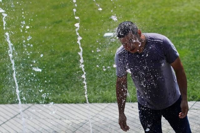 heat wave, man in sprinkler