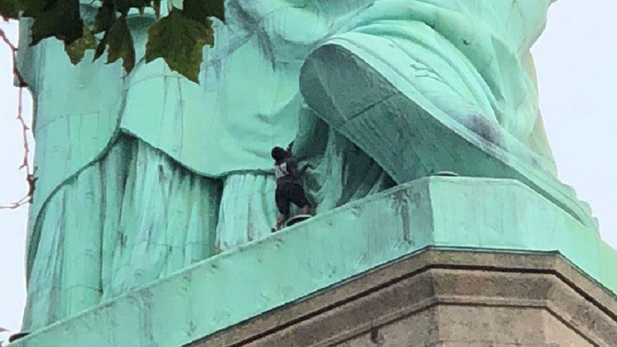 ICE protestor climbs statue of liberty
