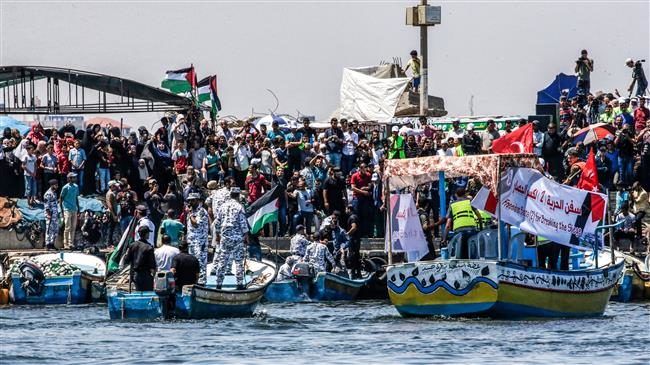 Activists attend an event on a pier in the Gaza City harbor for the launch of a blockade-running boat, surrounded by boats carrying members of Hamas’ marine police