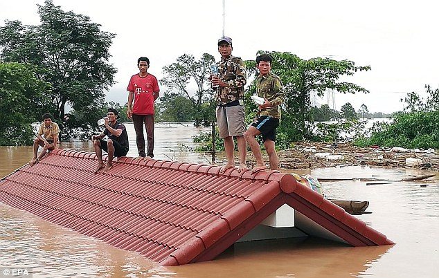 Click to enlarge Many Lao villagers are stranded on the roofs of their homes after fleeing floodwaters caused by the Xe Pian Xe Nam Noy hydroelectric dam burst