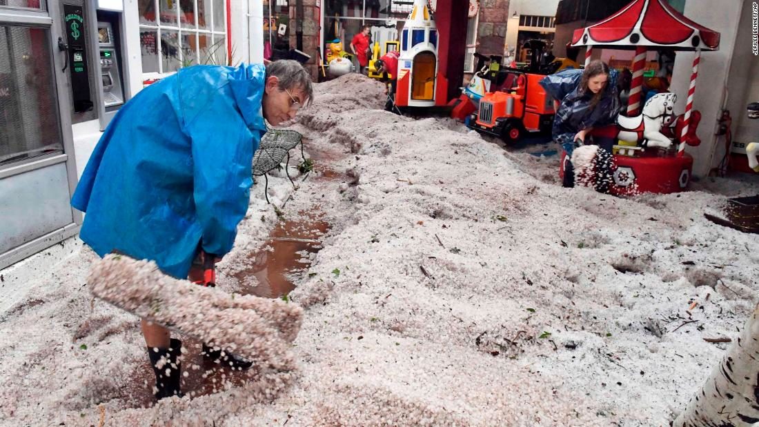 Ron Allen, an employee with the Manitou Springs Penny Arcade, and other employees dig out of hail drifts at the arcade in Manitou Springs, Colo., Monday, July 23, 2018. A storm dropped hail and caused flash flood and tornado warnings for the area.