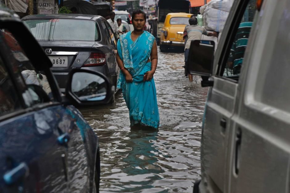 Indian woman walks in flooded street