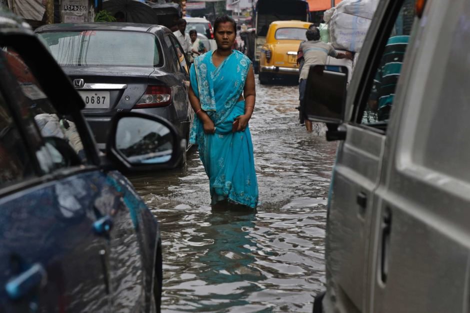 Indian woman walks in flooded street