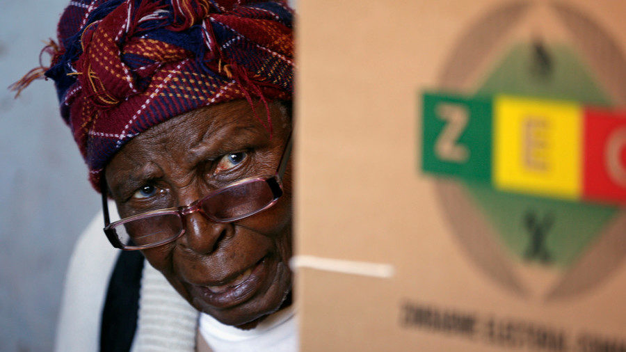 A woman looks on after casting her ballot in the country's general elections in Harare