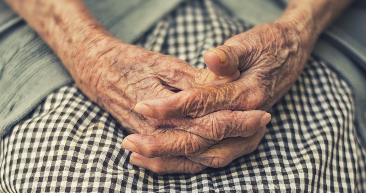 elderly woman with hands folded
