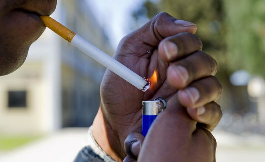 Click to enlarge Man lighting a cigarette