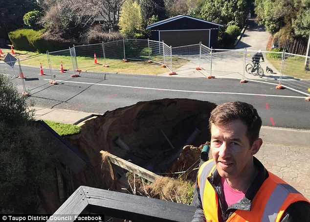A sinkhole that consumed a significant part of a suburban road was discovered by two teenagers who noticed a water broken water pipe