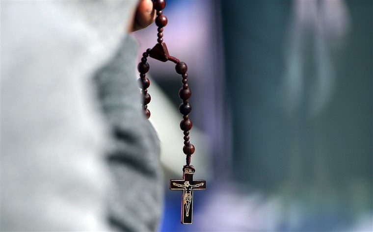 A man prays at the Benjamin Franklin Parkway as he waits for Pope Francis to lead an open-air mass in Philadelphia, Pennsylvania on Sept. 27, 2015.