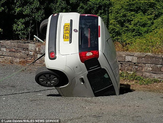Click to enlarge This is the shocking moment a woman saw her car parked on the grounds of a castle in Wales swallowed by a sinkhole. Karen Davies, 54, found her Fiat had disappeared as she finished her shift