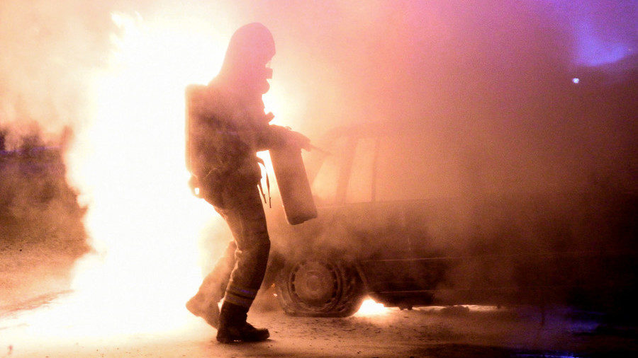 Swedish firefighter trying to extinguish a burning car.