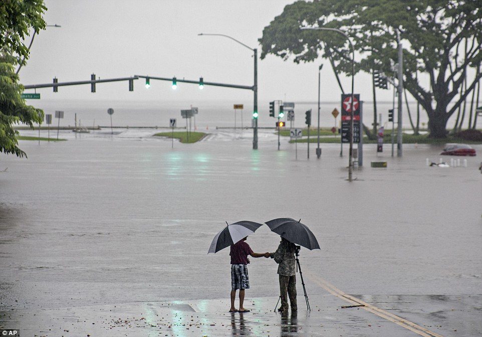 Click to enlarge People stand near flood waters from Lane making the intersection of Kamehameha Avenue and Pauahi Street impassable