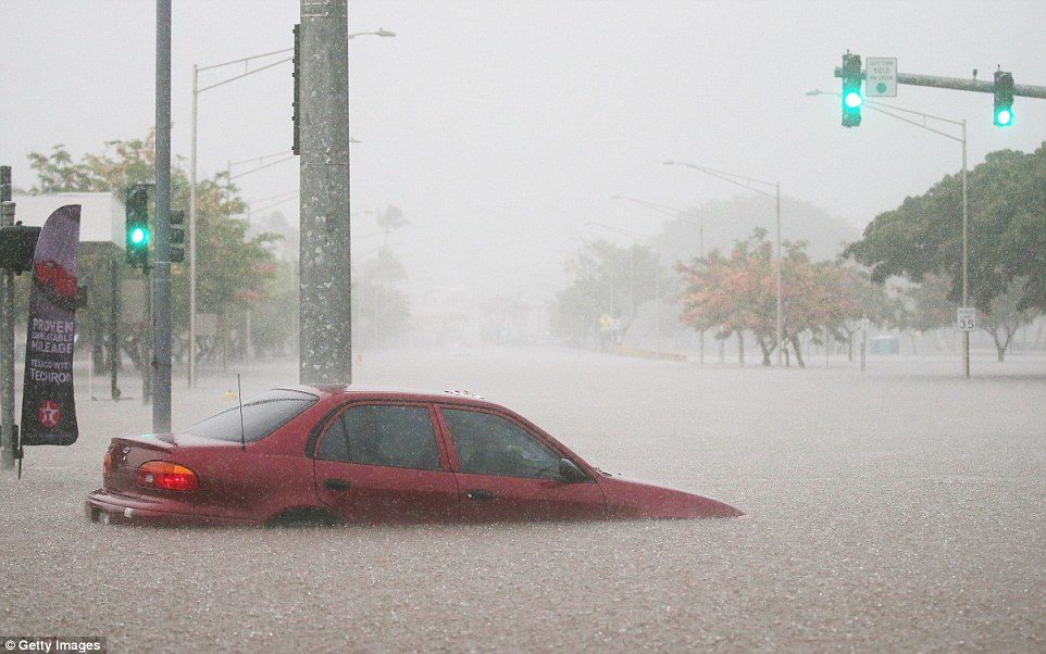A car is partially submerged in floodwaters from Hurricane Lane rainfall on the Big Island on August 23 in Hilo, Hawaii
