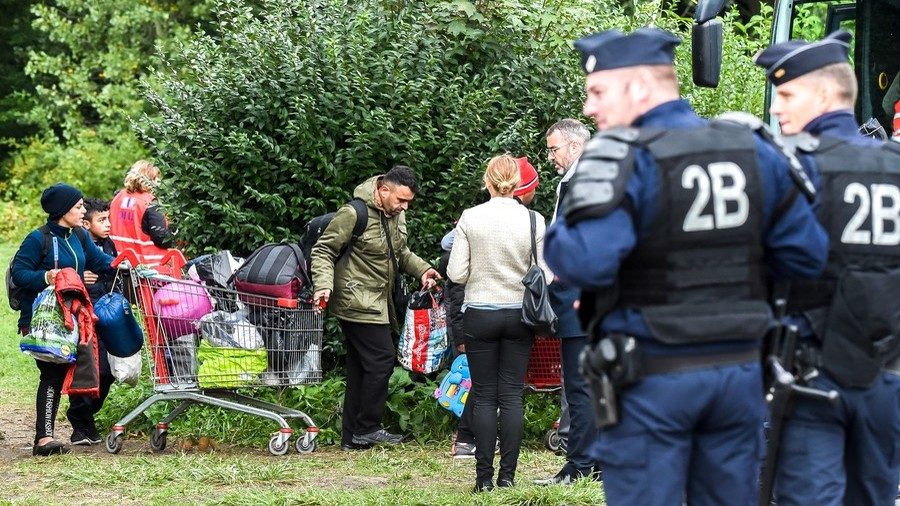 Click to enlarge Police oversee people leaving the migrant camp near the port city of Dunkirk