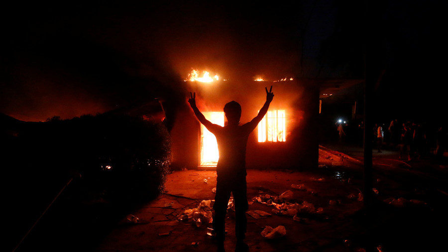 Protester in front of the burnt Iranian Consulate in Basra