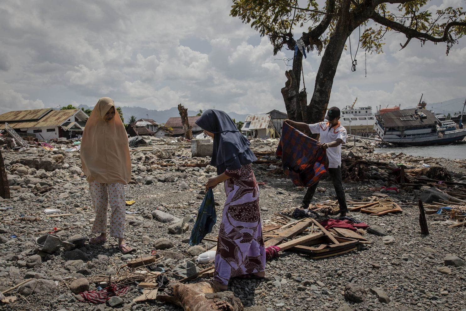 Click to enlarge People search for belongings amongst the debris of houses in Donggala
