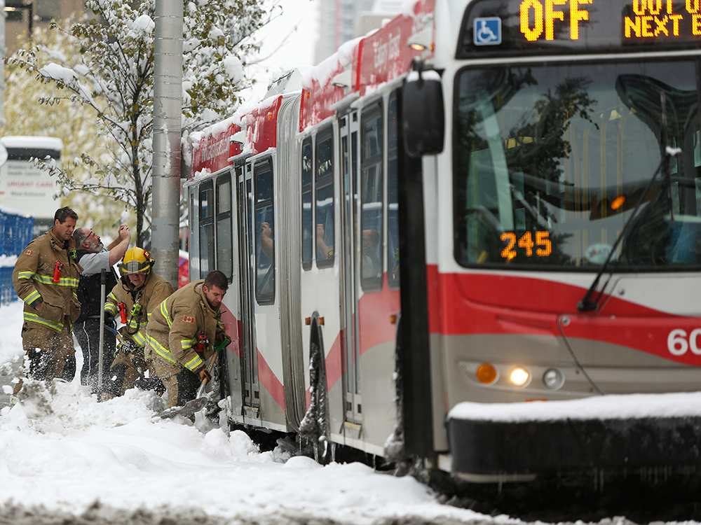 Firefighters help dig out a stranded bus