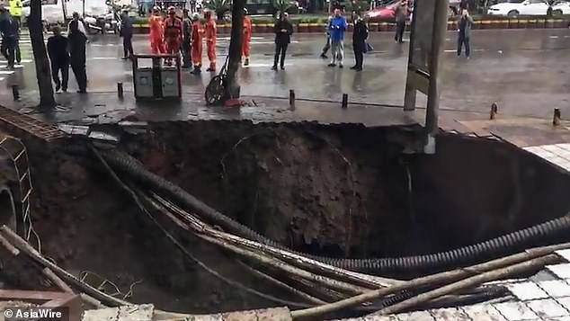 Click to enlarge Two people were killed in south-west China's Sichuan province after a massive sinkhole swallowed four pedestrians on Sunday afternoon. Two others remained missing