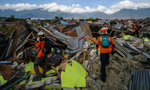 An Indonesian search and rescue team walk amongst the debris in Petobo, Indonesia