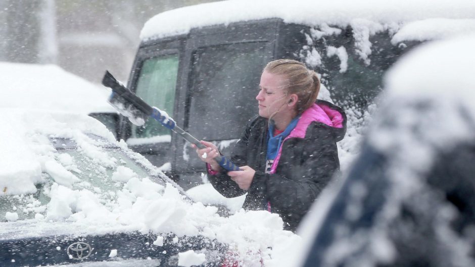 UND student Kristin Hane clears away snow