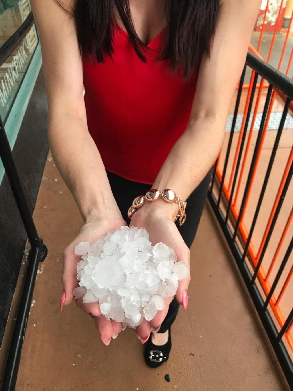 Click to enlarge A Gympie resident with handfuls of hail