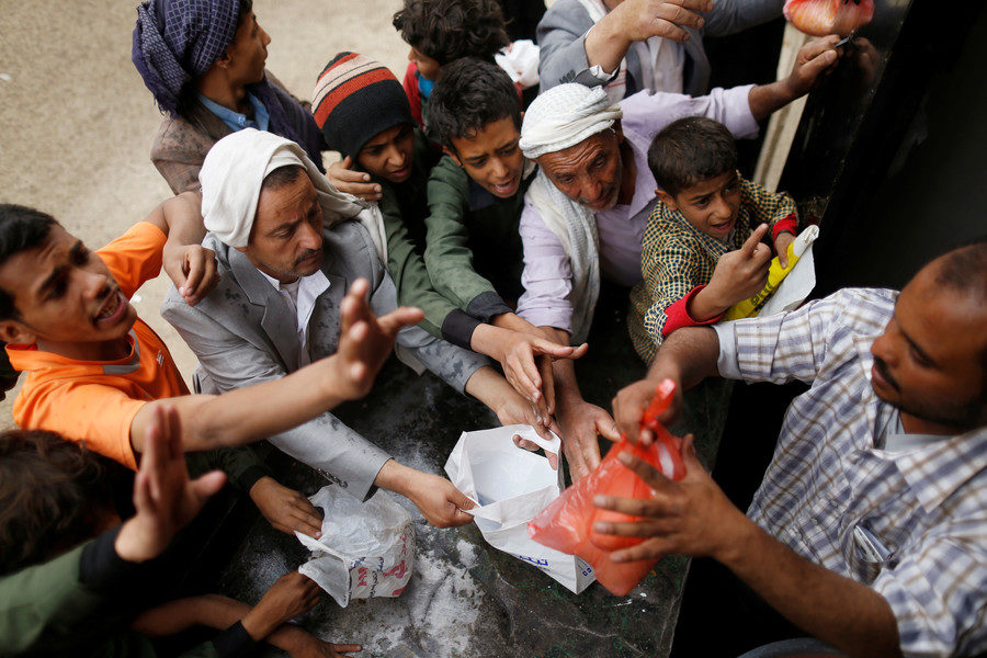 Click to enlarge People gather to collect food rations
