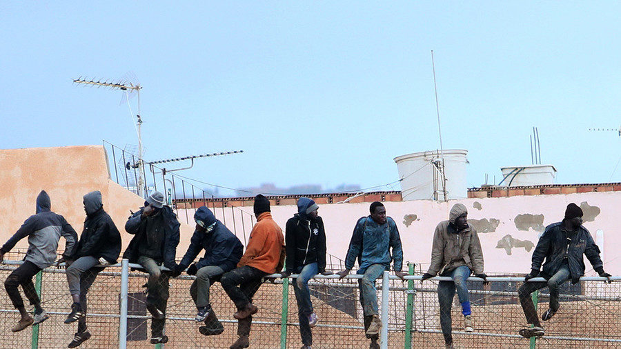 In this file photo taken on February 19, 2015 migrants sit atop a border fence separating Morocco from the north African Spanish enclave of Melilla.