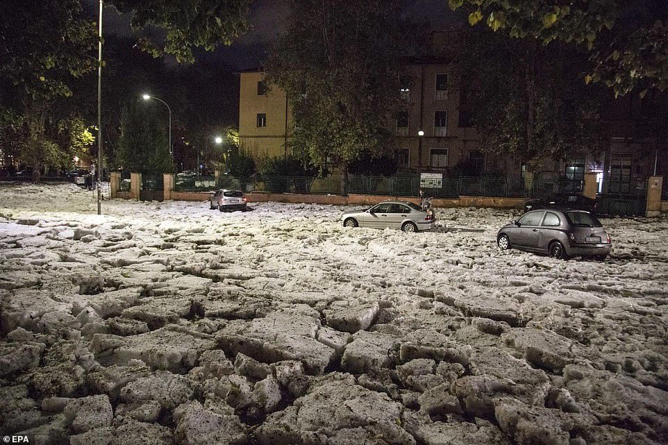 Cars are blocked in a road covered with massive chunks of hail in Rome after a storm and torrential rain hit the area