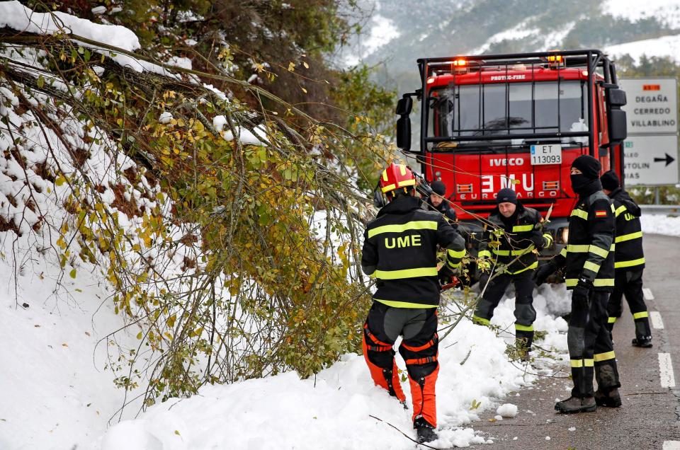 Spanish Emergency Services personnel help clearing snow off a road in Degana, Asturias