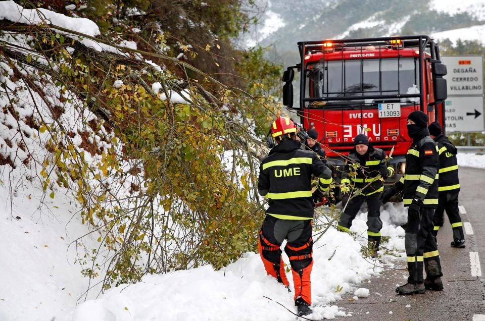 Spanish Emergency Services personnel help clearing snow off a road in Degana, Asturias