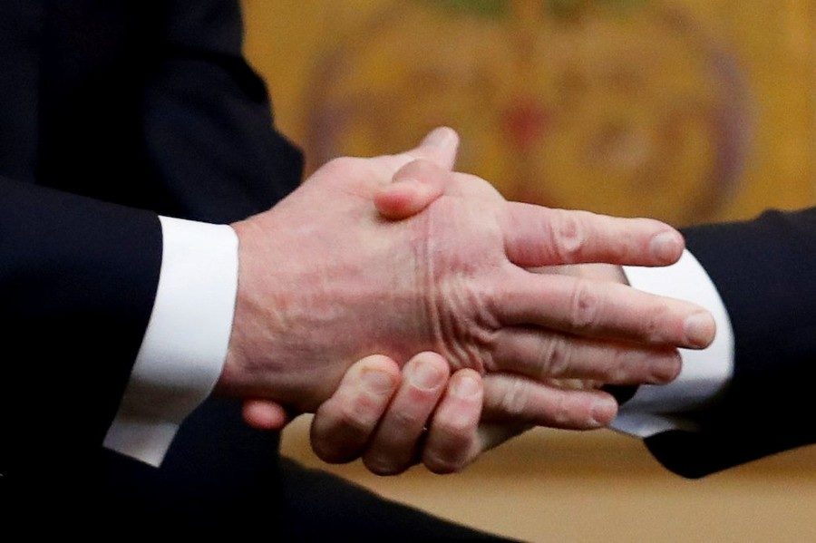 Emmanuel Macron shakes Donald Trump‘s hand as they meet on Staurday.