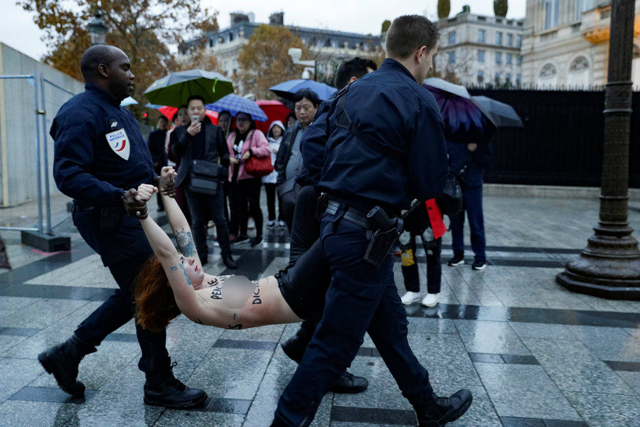 Click to enlarge Police dragged the protestors towards waiting vehicles while tourists watch