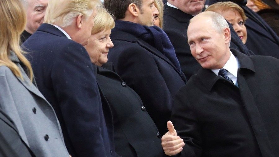 Russian President Vladimir Putin talks with German Chancellor Angela Merkel and U.S. President Donald Trump as they attend a commemoration ceremony for Armistice Day in Paris, France, November 11, 2018
