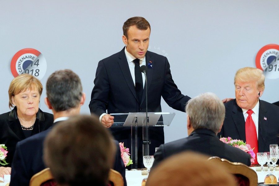 French President Emmanuel Macron is flanked by U.S. President Donald Trump and German Chancellor Angela Merkel, as he delivers a speech before a lunch at the Elysee Palace, Paris, France, November 11, 2018
