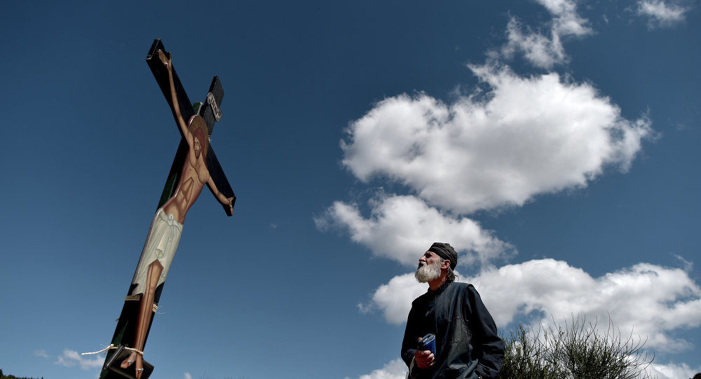 priest looking at jesus on cross