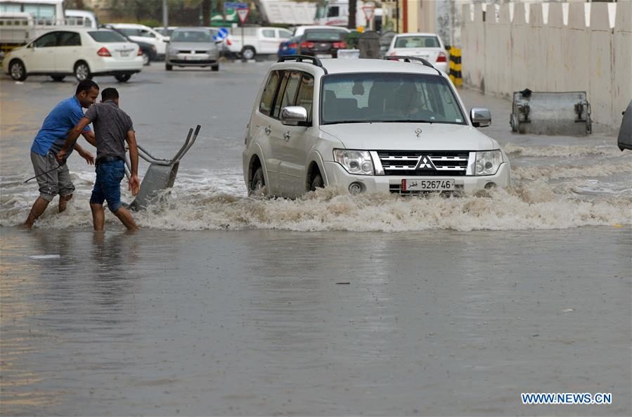 A motorist drives through the flooded streets,