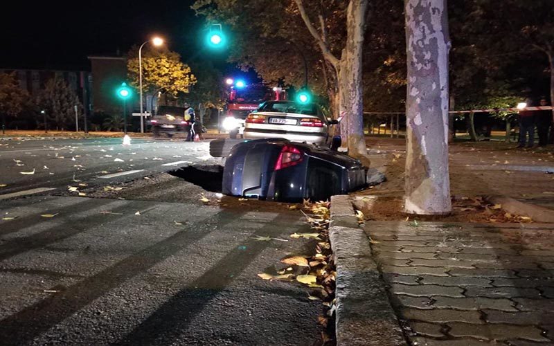 The car toppled over and into the gaping hole.