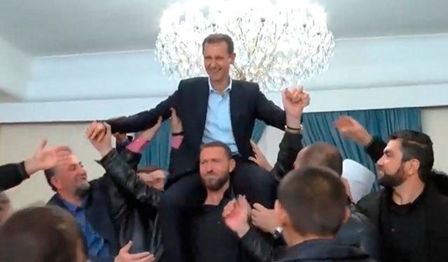 Click to enlarge Assad shoulders celebrate