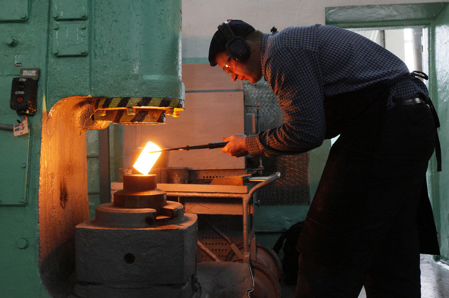 Click to enlarge A melter foreman works on an ingot of 99.98 percent pure palladium